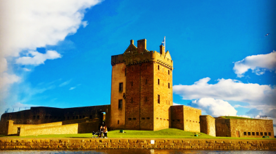 Historic castle with moat and blue sky on a sunny day.